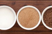 Weisser raffinierter, brauner und schwarzer Zucker in weissen Schälchen von oben fotografiert zuckersorten